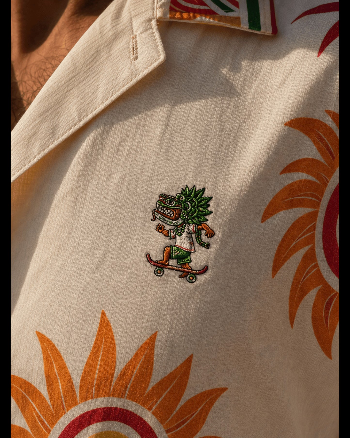 Retrooo.com Quetzalcoatl Skater Hawaiian shirt in cream with embroidered deity on chest and orange sun print